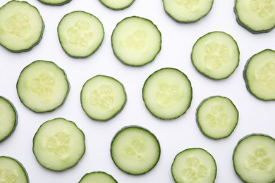 Photo of Fresh slices of cucumbers on white background, top view