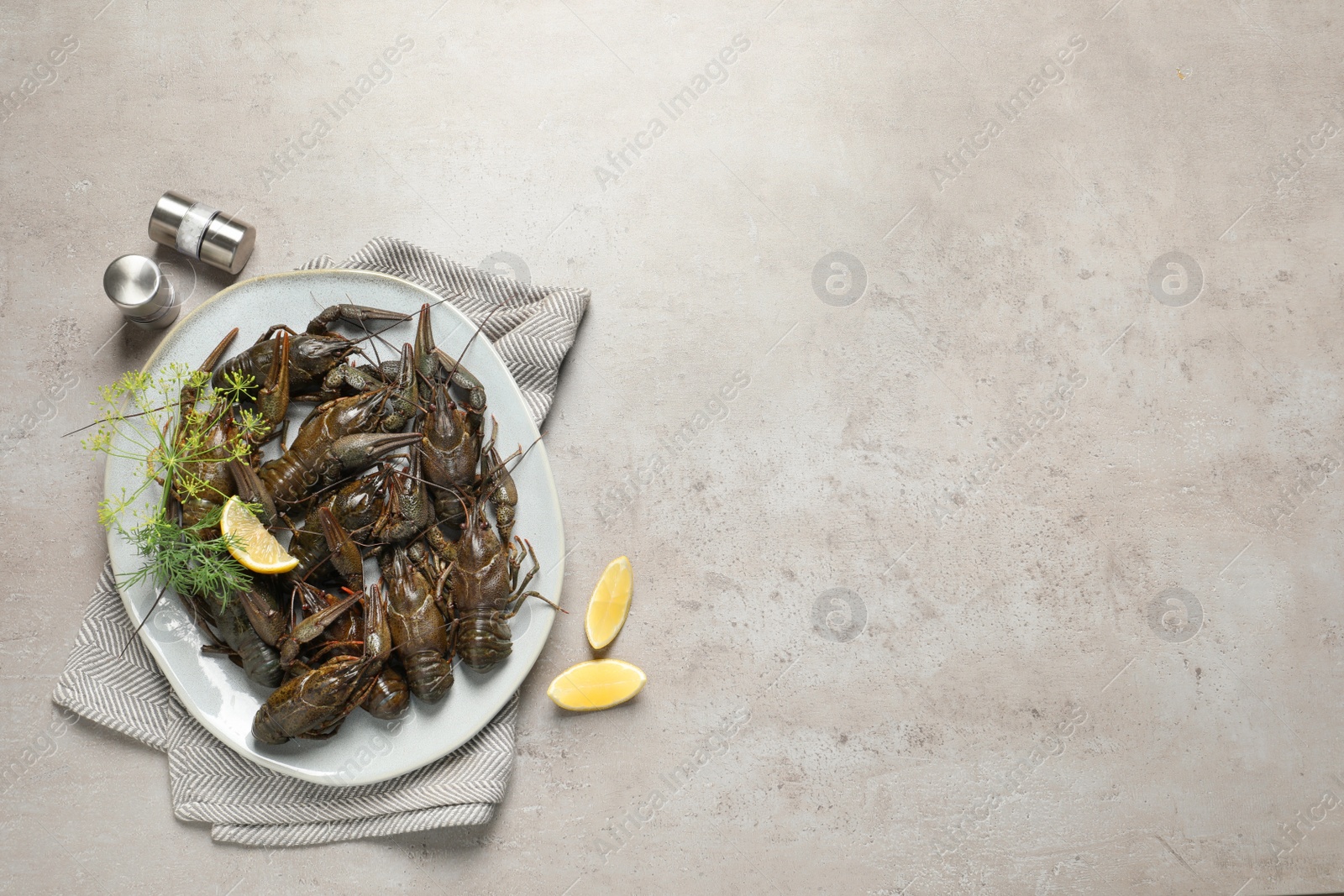 Photo of Fresh raw crayfishes with lemon and dill on light grey table, flat lay. Space for text