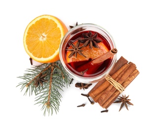 Photo of Glass of mulled wine with fir branch, cinnamon and orange isolated on white, top view