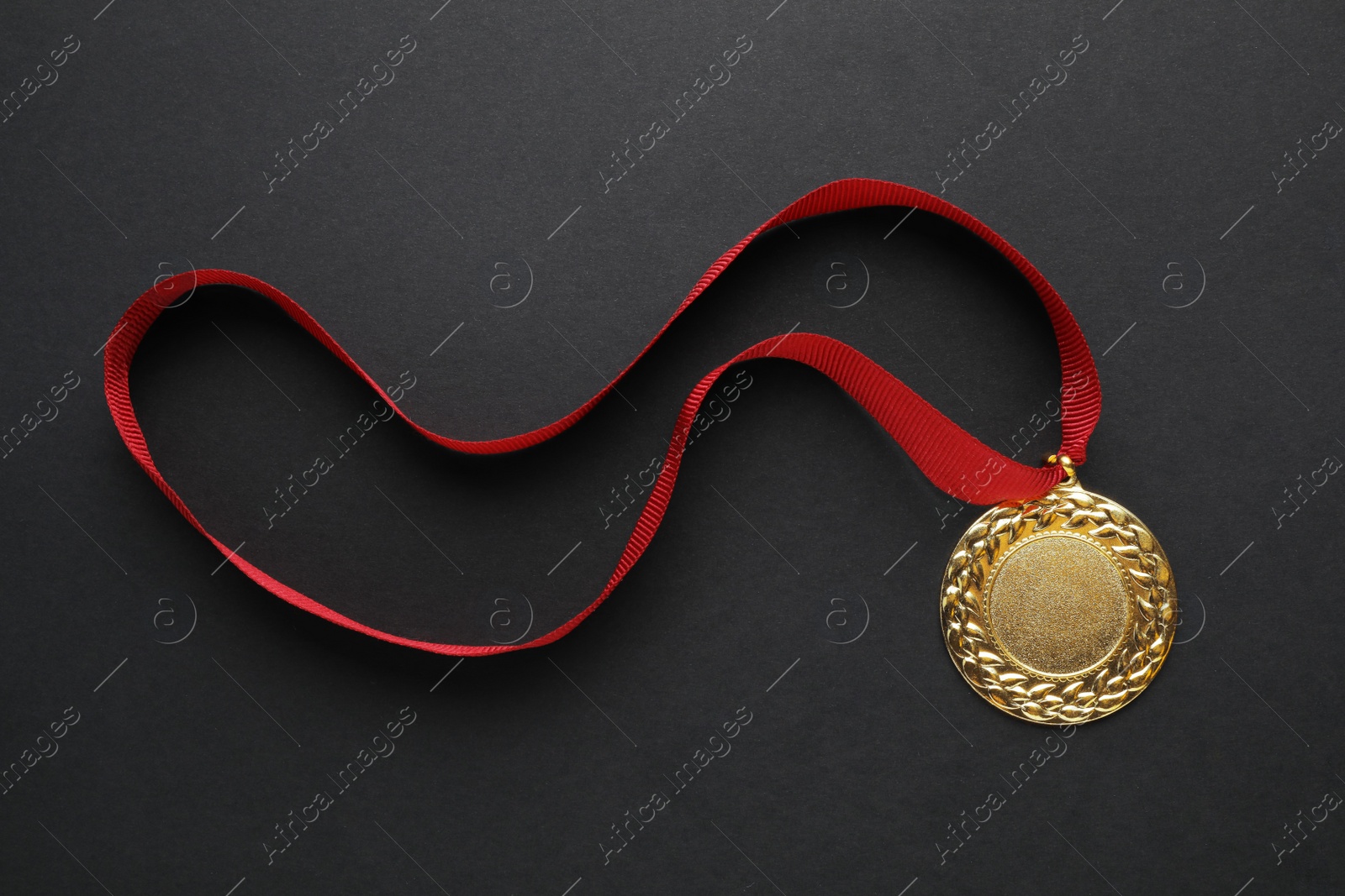 Photo of Gold medal with space for design on black background, top view. Victory concept