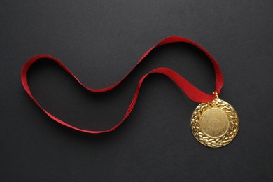 Gold medal with space for design on black background, top view. Victory concept