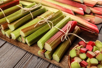 Photo of Many cut rhubarb stalks on wooden table, closeup