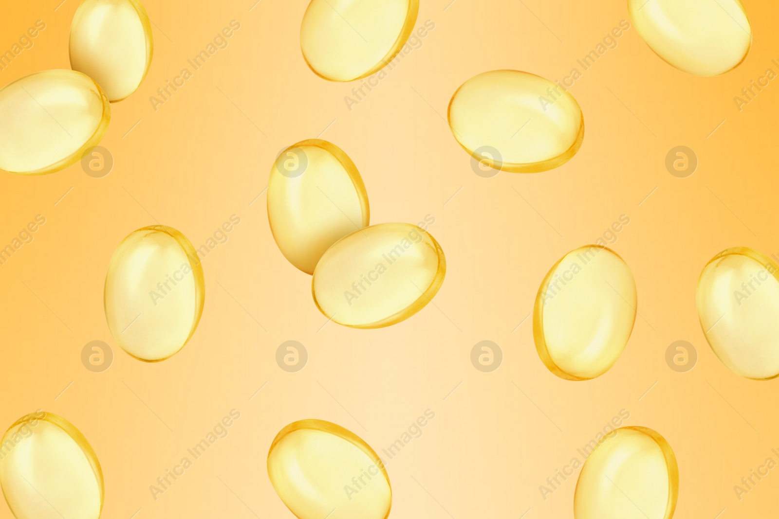 Image of Vitamin. Softgel capsules falling on orange gradient background