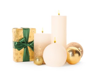 Beautiful burning candles with Christmas gift and baubles on white background