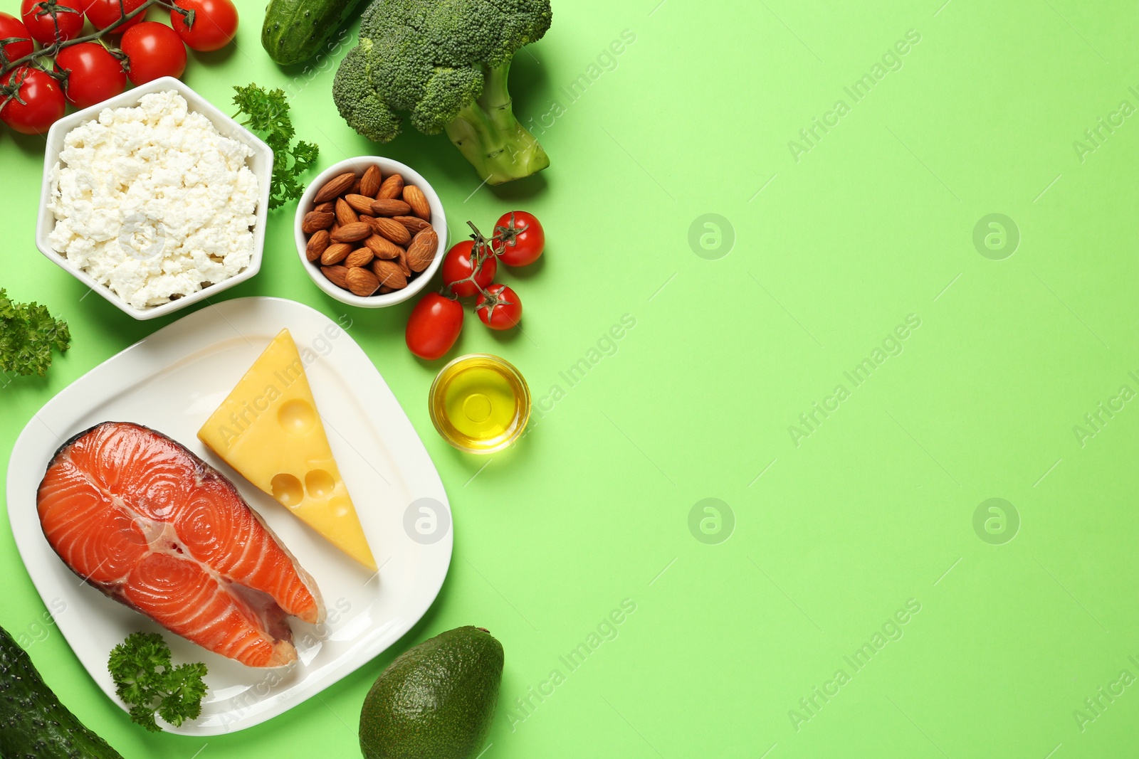 Photo of Different products on light green background, flat lay with space for text. Keto diet