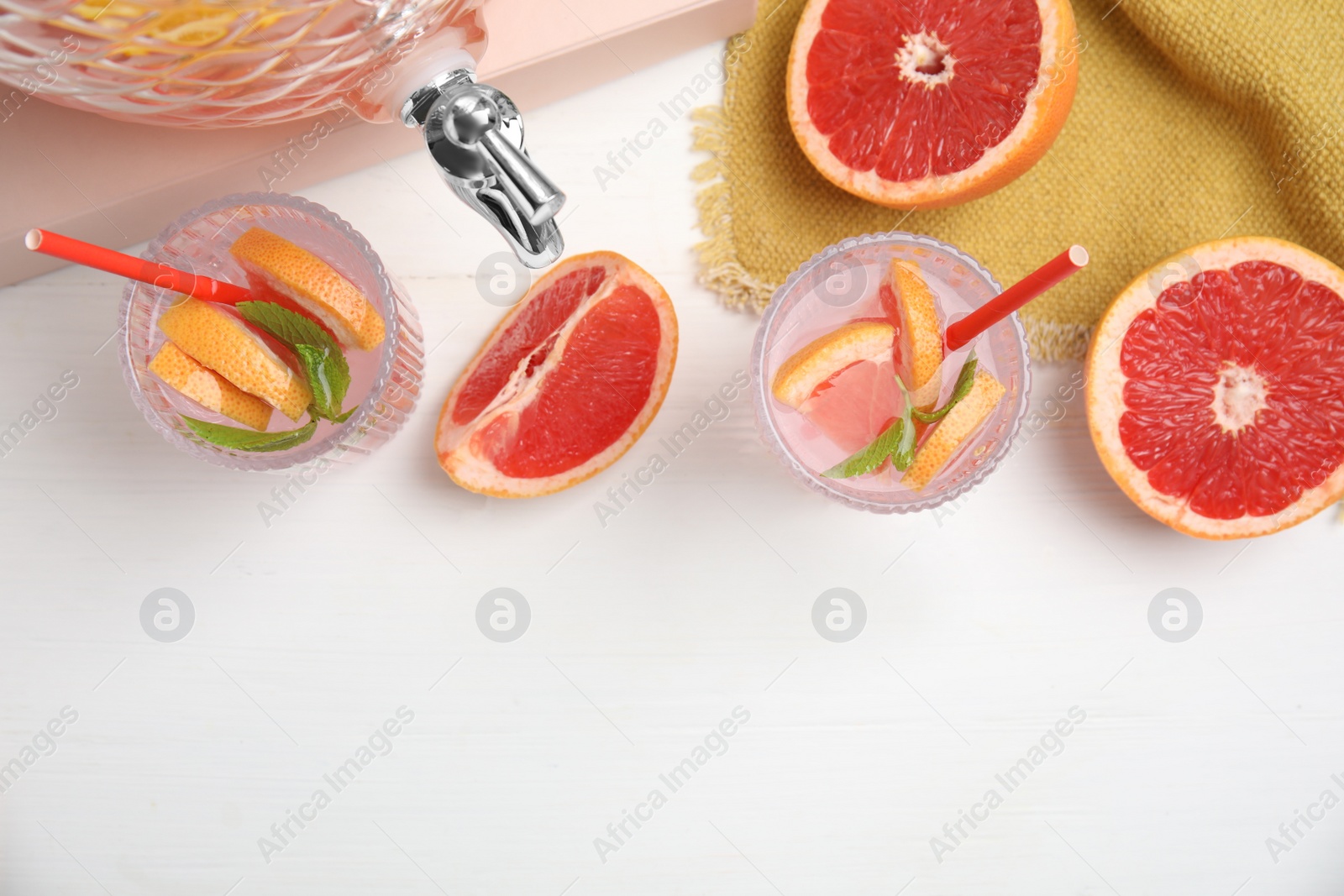 Photo of Delicious refreshing drink with grapefruit and mint on white wooden table, flat lay. Space for text