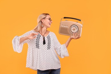 Photo of Portrait of happy hippie woman with retro radio receiver on yellow background