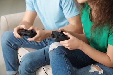 Photo of Young couple playing video games at home, closeup