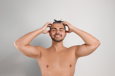 Photo of Young man washing hair on white background