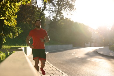 Photo of Man running outdoors on sunny day. Space for text