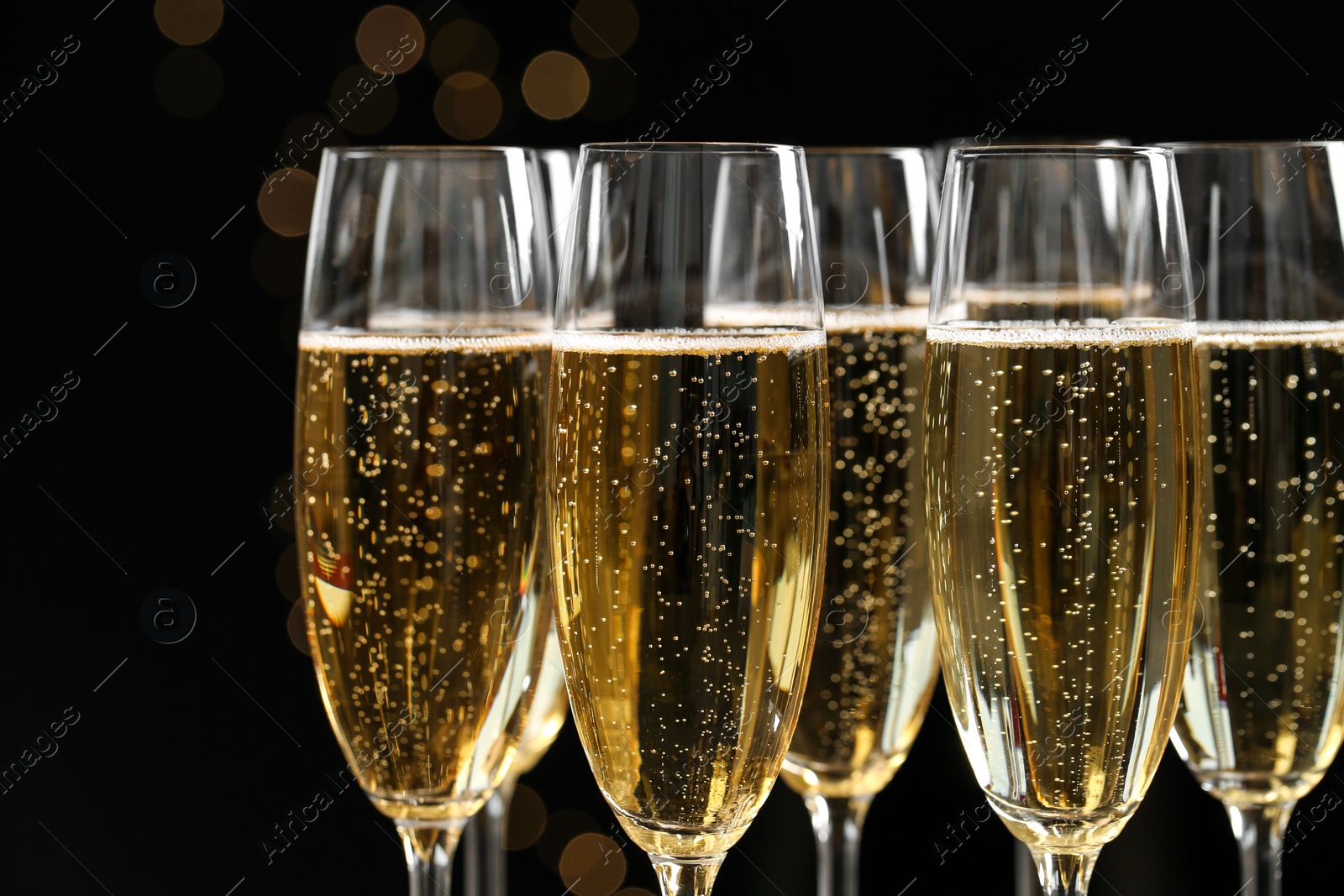 Photo of Many glasses of champagne on blurred background, closeup