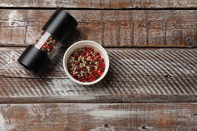 Photo of Different peppercorns on wooden table, flat lay. Space for text