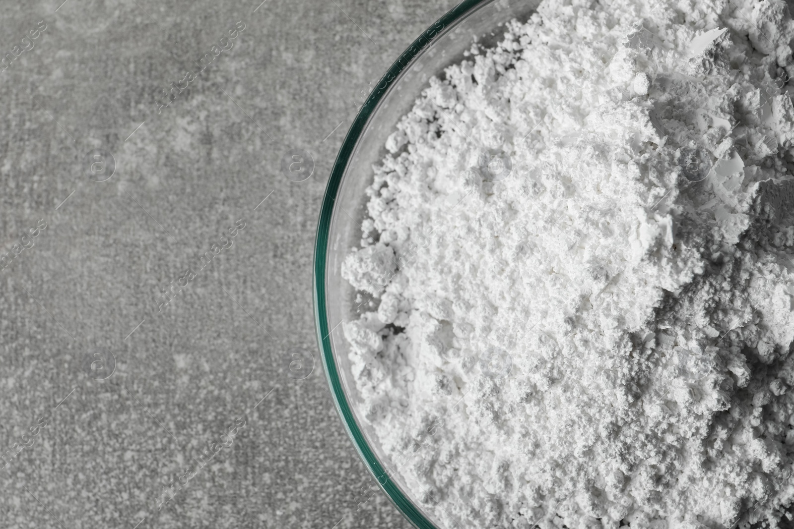 Photo of Petri dish with calcium carbonate powder on light grey table, closeup. Space for text