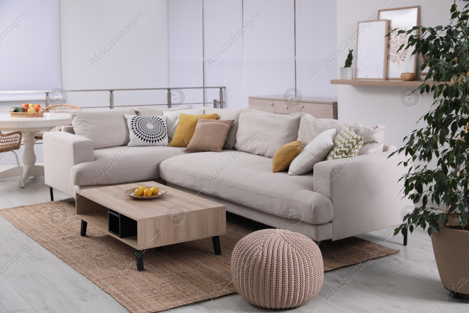 Photo of Stylish living room interior with comfortable grey sofa and coffee table