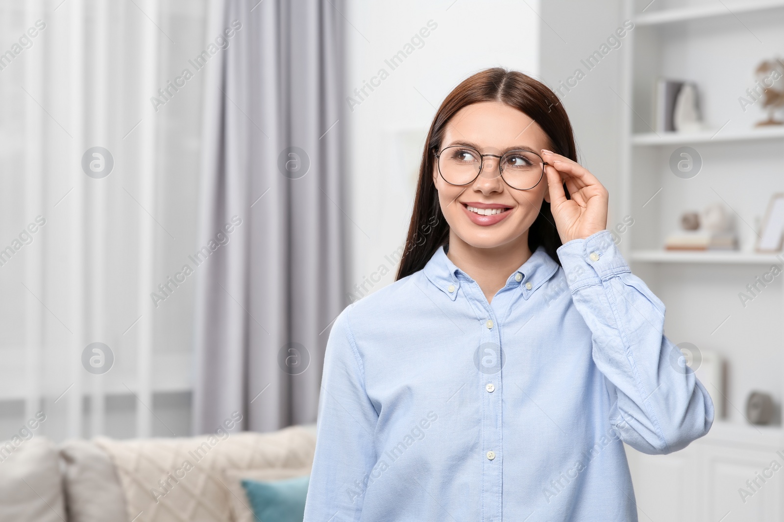 Photo of Smiling woman in stylish eyeglasses at home. Space for text