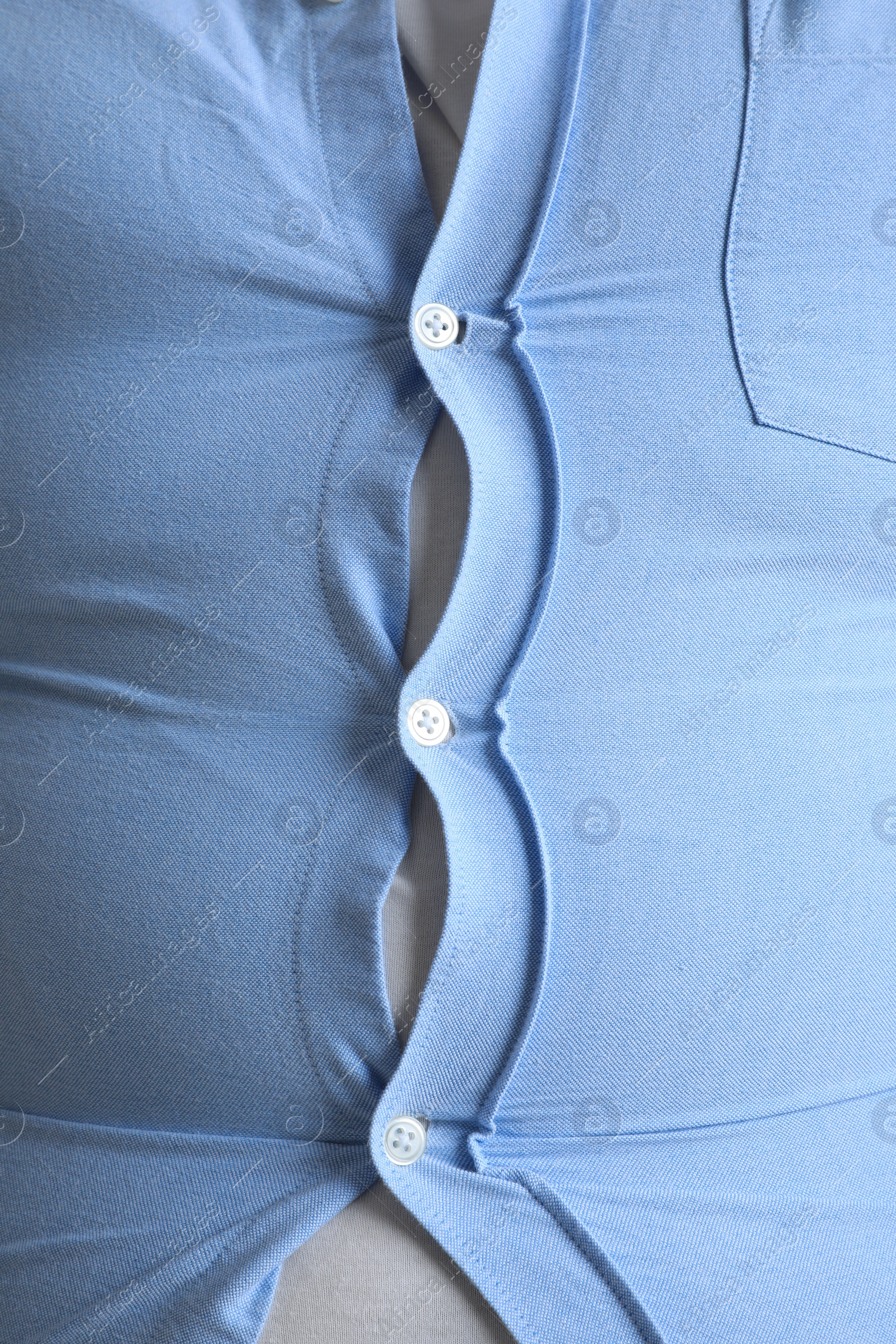 Photo of Closeup view of overweight man in tight shirt as background