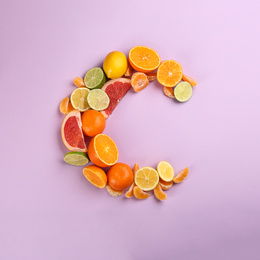 Photo of Letter C made with citrus fruits on lilac background as vitamin representation, flat lay