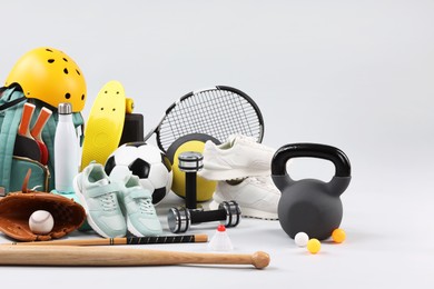 Photo of Many different sports equipment on light grey background