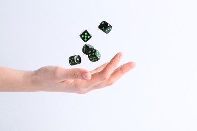 Photo of Woman throwing game dices on white background, closeup