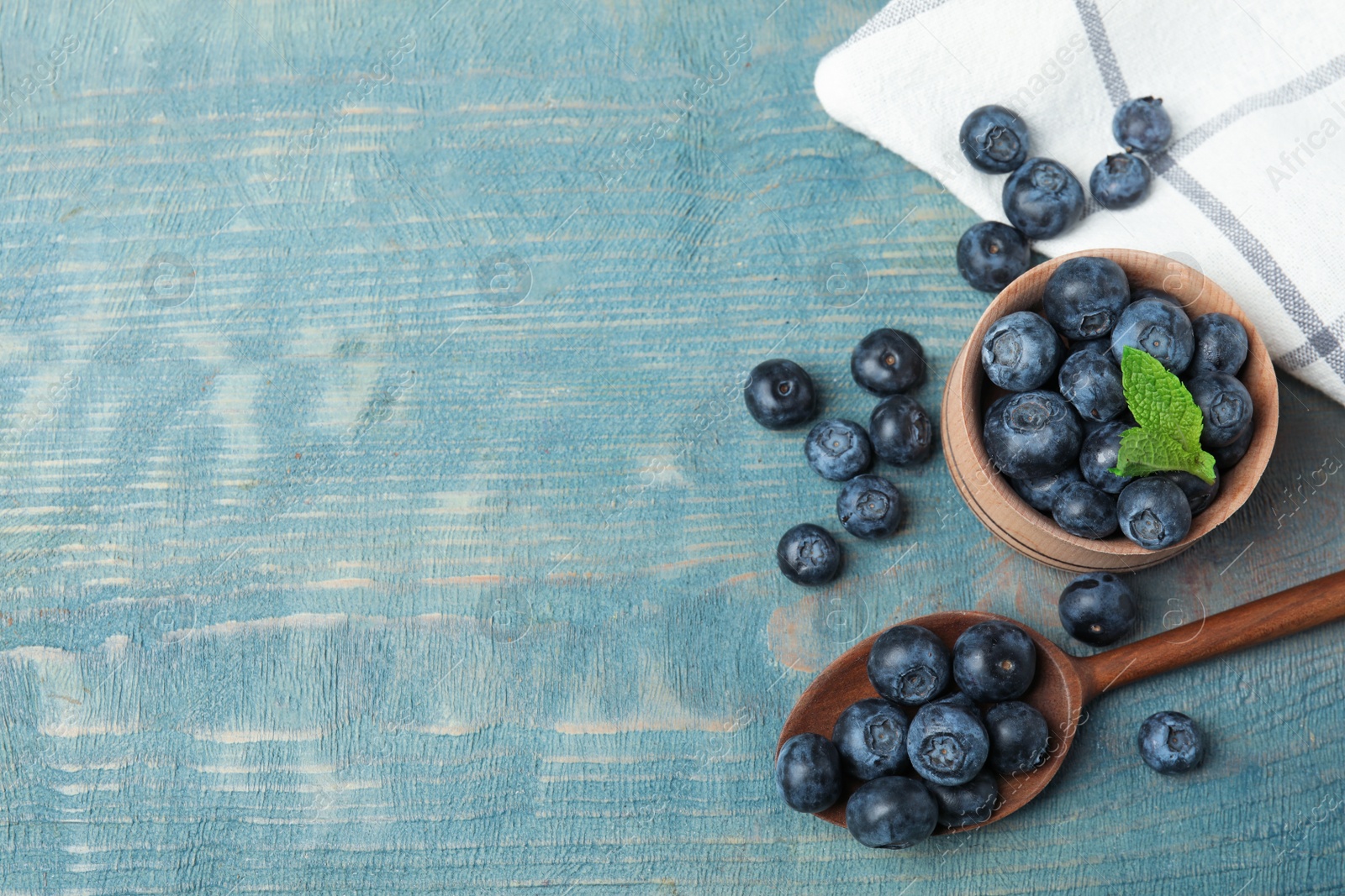 Photo of Flat lay composition of fresh blueberries and space for text on wooden table