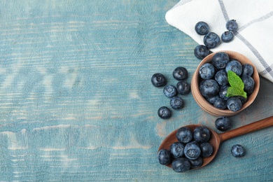 Photo of Flat lay composition of fresh blueberries and space for text on wooden table