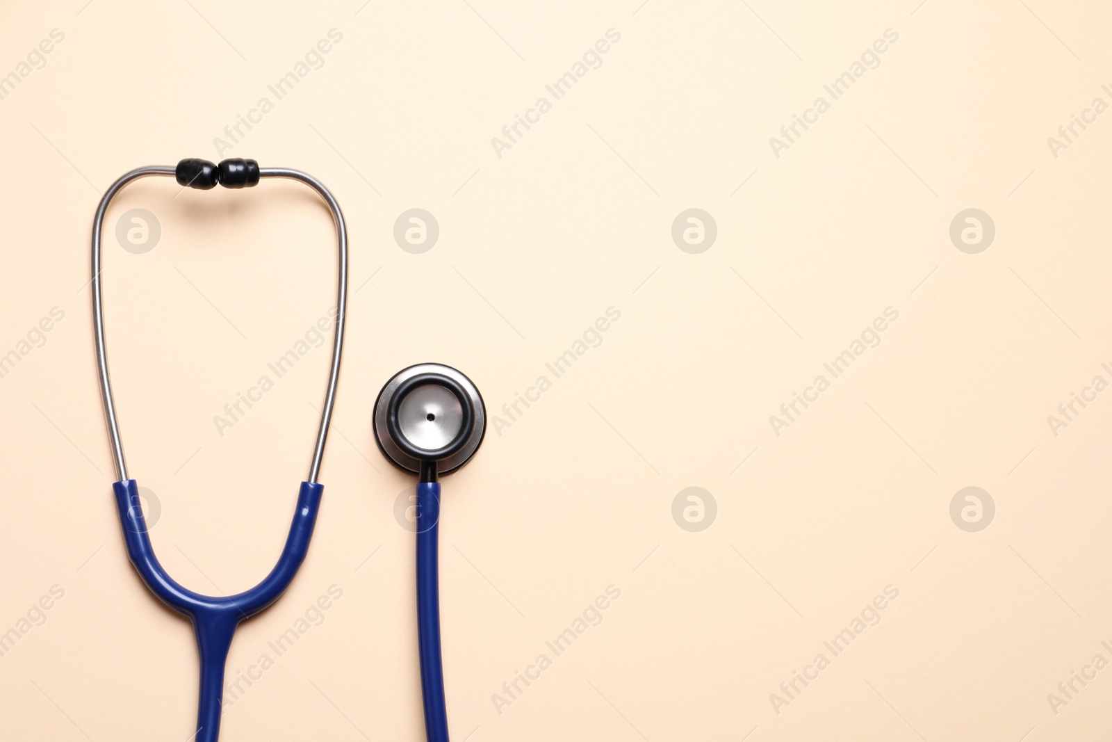 Photo of Stethoscope on beige background, top view. Space for text