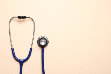 Photo of Stethoscope on beige background, top view. Space for text