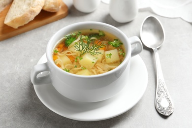 Photo of Dish of fresh homemade vegetable soup served on light grey table