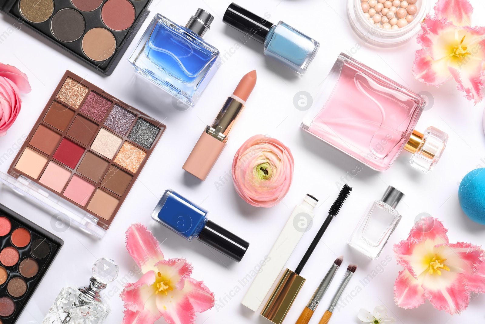 Photo of Flat lay composition with different makeup products and beautiful spring flowers on white background