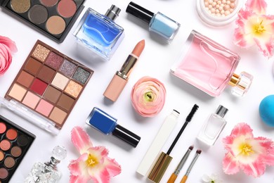 Photo of Flat lay composition with different makeup products and beautiful spring flowers on white background