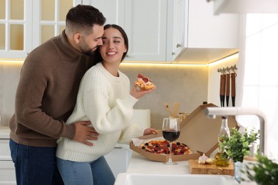 Photo of Affectionate young couple spending time together in kitchen. Space for text