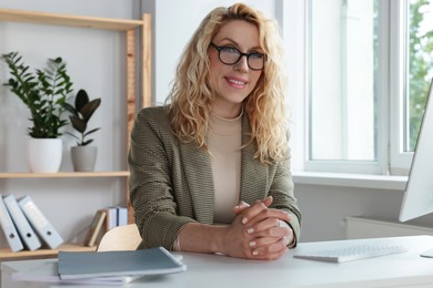 Photo of Portrait of beautiful young woman at desk in office