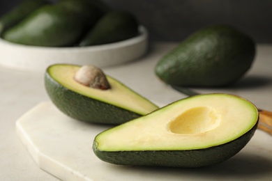 Halves of delicious ripe avocado on table