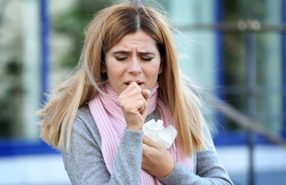 Woman suffering from cough and cold outdoors