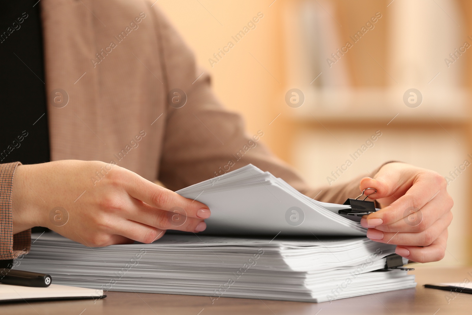 Photo of Woman working with documents at table in office, closeup