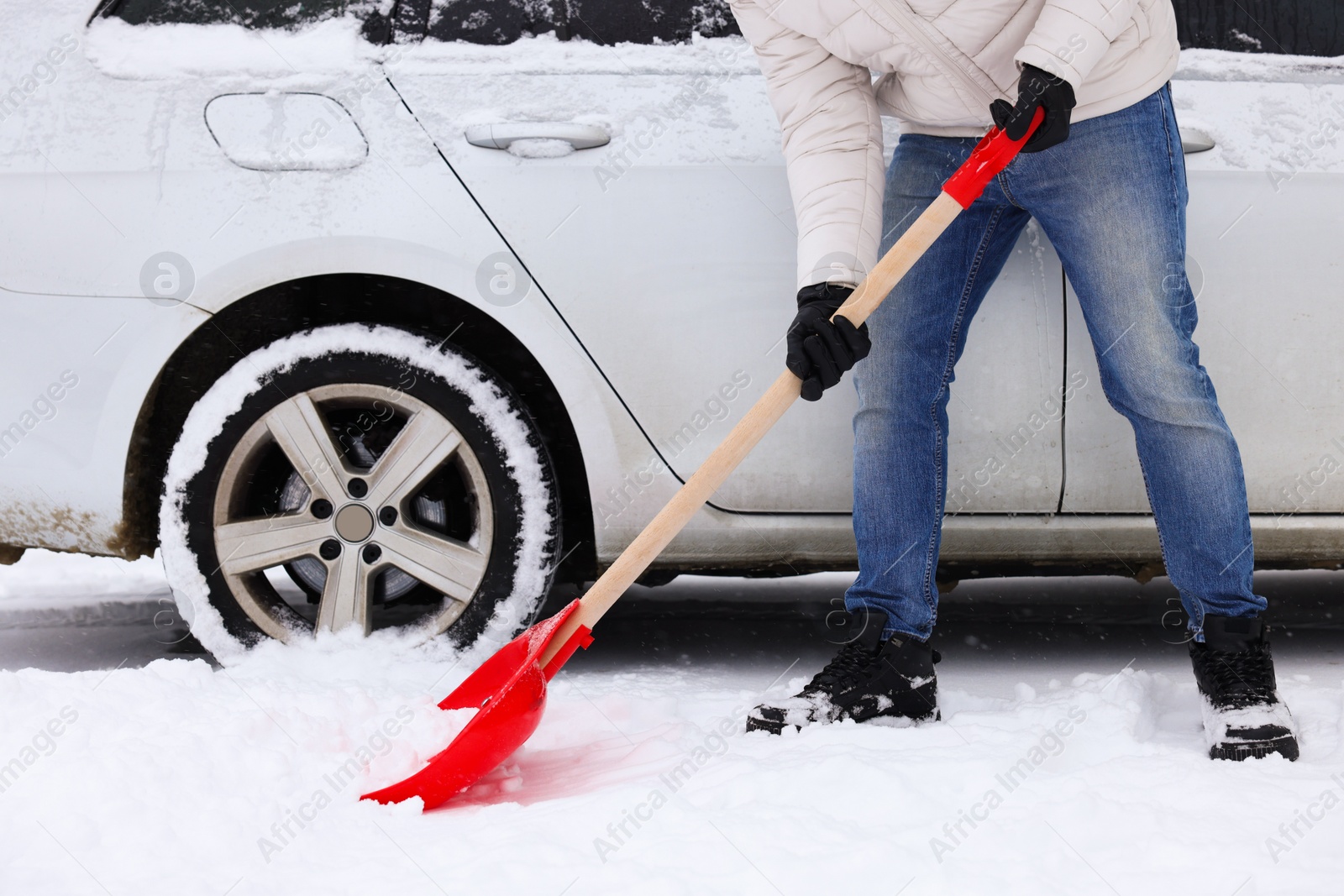 Photo of Man removing snow with shovel near car outdoors, closeup