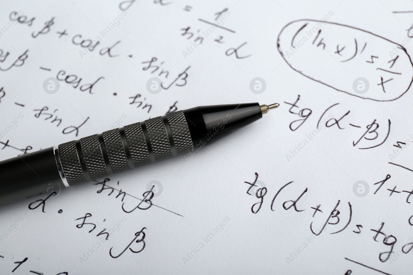 Photo of Sheet of paper with different mathematical formulas and pen, closeup