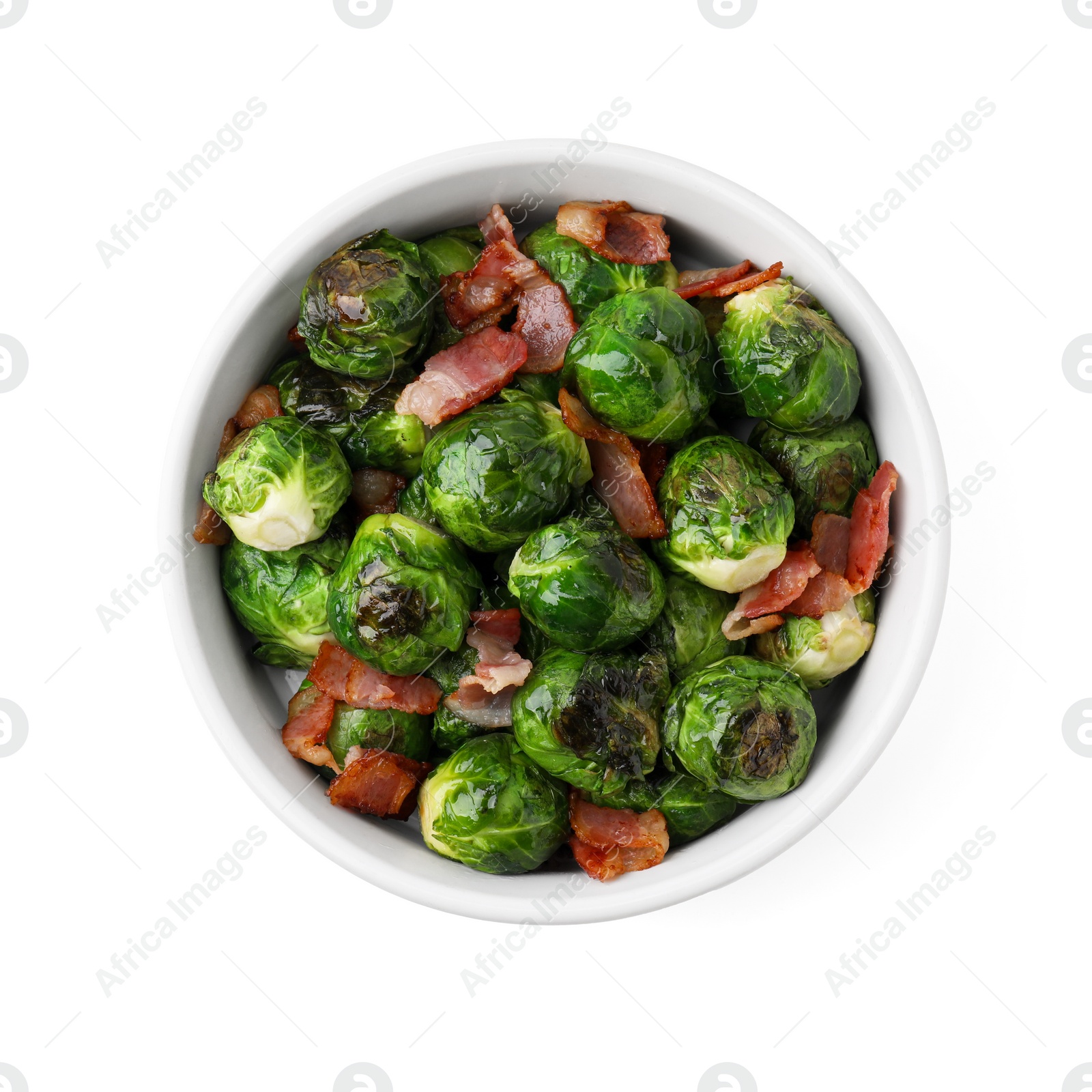 Photo of Delicious roasted Brussels sprouts and bacon in bowl isolated on white, top view