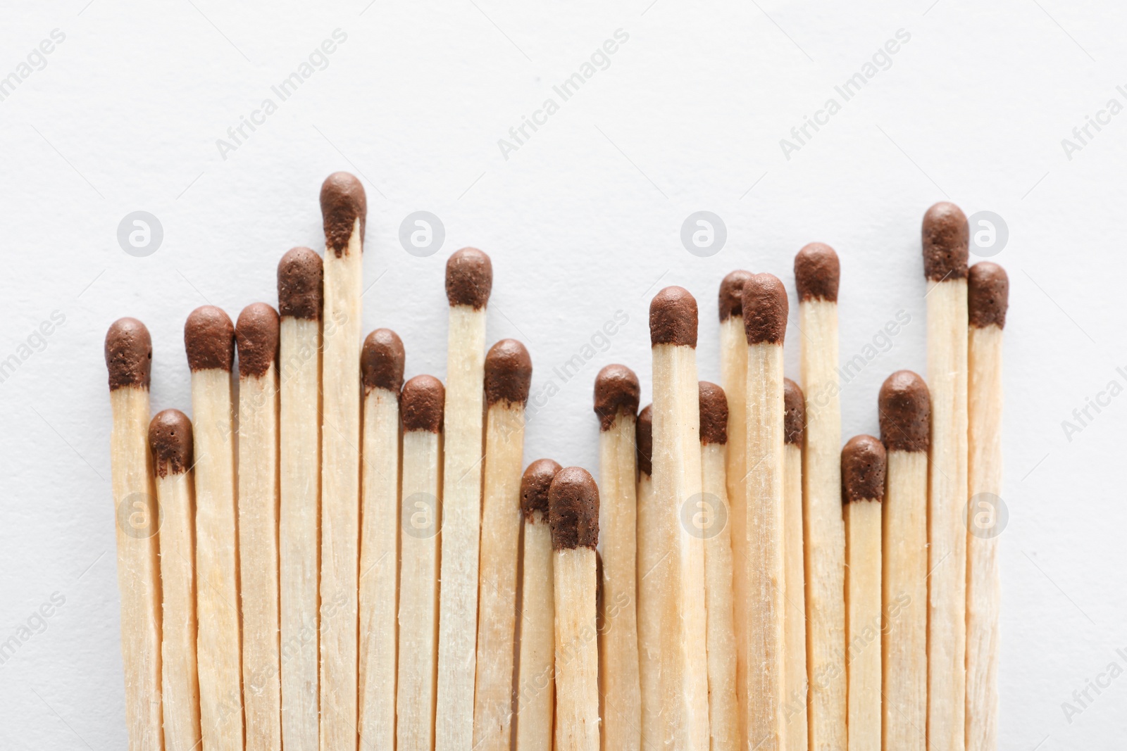 Photo of Pile of wooden matches on white background, top view