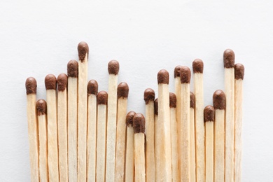 Photo of Pile of wooden matches on white background, top view