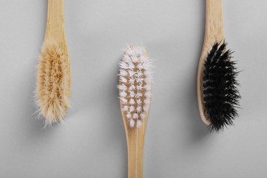 Bamboo toothbrushes on light background, flat lay