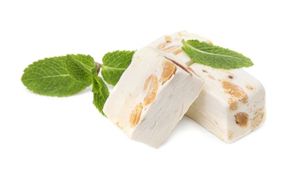 Photo of Pieces of delicious nougat and mint on white background