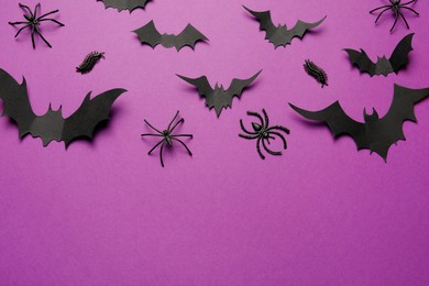 Photo of Flat lay composition with paper bats and spiders on purple background, space for text. Halloween celebration