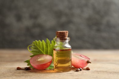 Photo of Bottle of natural grape seed oil on wooden table. Organic cosmetic