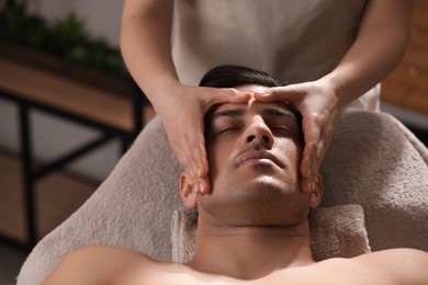 Photo of Man receiving facial massage in beauty salon