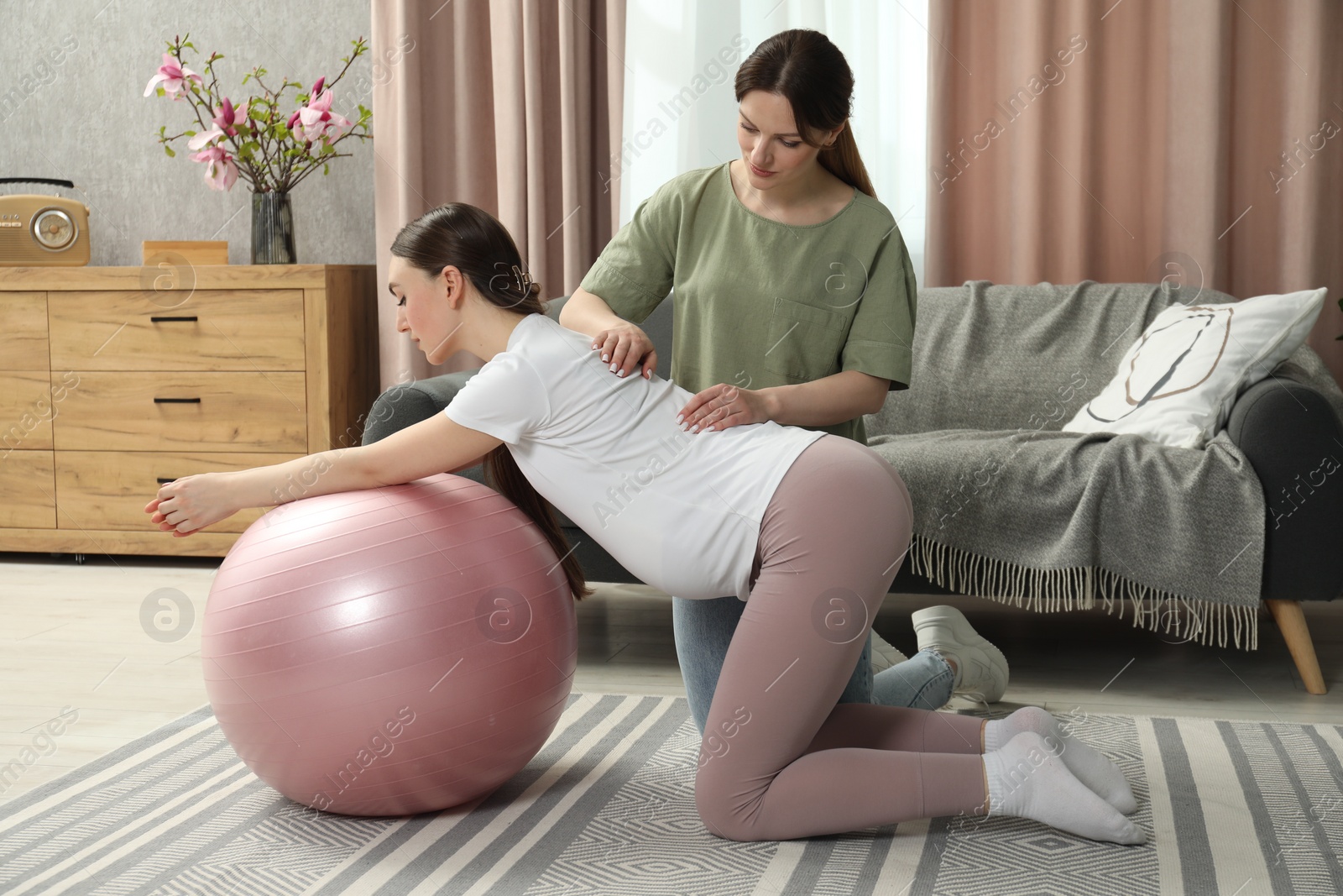 Photo of Doula massaging pregnant woman at home. Preparation for child birth