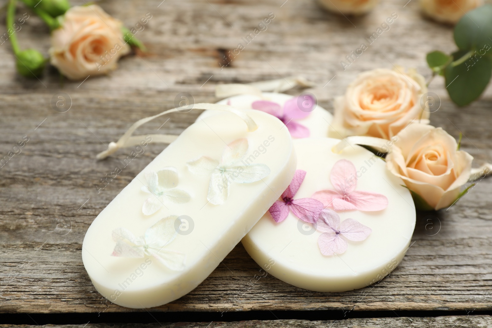 Photo of Scented sachets and flowers on wooden table