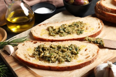 Tasty bruschettas with pesto on wooden board, closeup