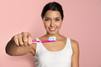 Photo of Young woman with toothbrush and paste on color background. Teeth care