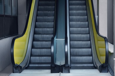 Photo of View on empty parallel escalators with yellow balustrades